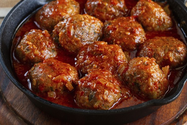 Minced meat meatballs, in tomato sauce, in a cast-iron pan, homemade, no people