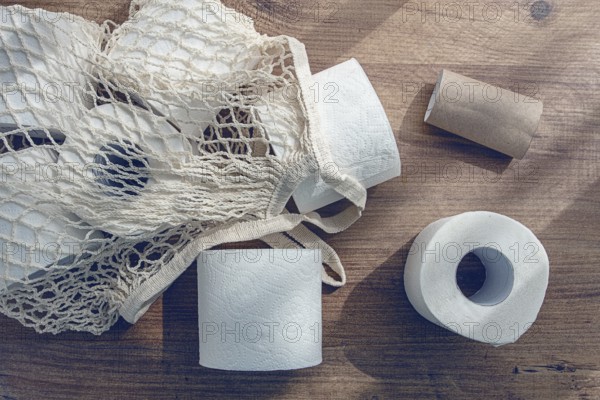 Mesh bag on the table, with rolls of toilet paper, top view, no people