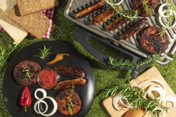 Grilled food with ketchup on a plate and grill, surrounded by bread and herbs
