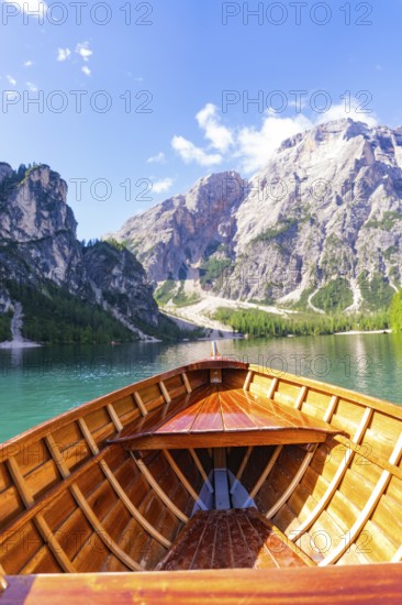 Perspective from the boat towards the majestic mountain landscape over clear water, Pragser Wildsee, South Tyrol, Dolomites, Italy