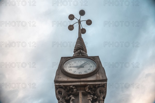 Low angle view of a clock tower in bordeaux, france, with a cloudy sky as backdrop, showcasing the city's historical architecture
