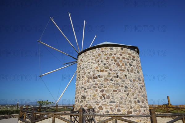 Stone windmill with wooden railings under a blue sky, Kefalos, Kos, Dodecanese, Greek Islands, Greece