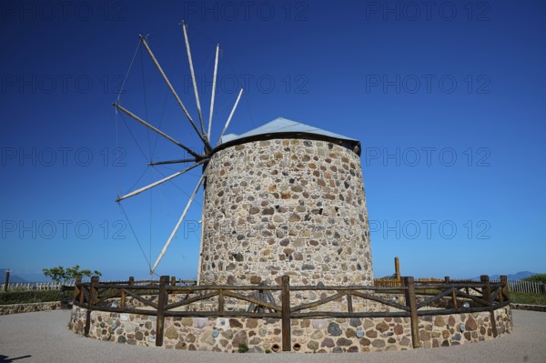 Historic stone windmill with fence and clear sky, Kefalos, Kos, Dodecanese, Greek Islands, Greece