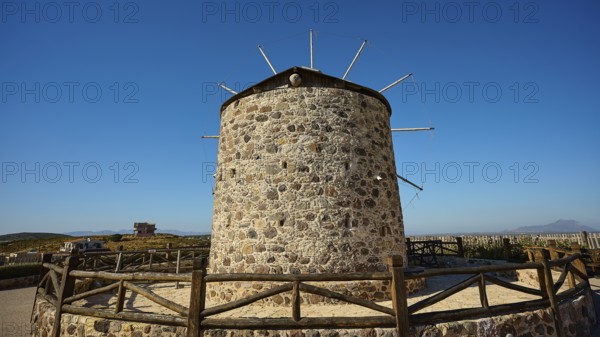 Stone windmill under a wide blue sky in a rural setting, Kefalos, Kos, Dodecanese, Greek Islands, Greece