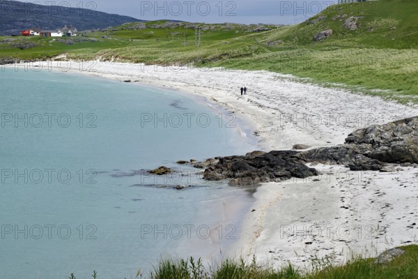 A quiet beach with white sand, green grass and a cloudy sky, Eriksay, Hebrides, Scotland, United Kingdom