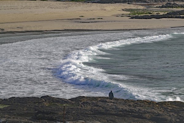 Rocky coast with crashing waves and lonely viewer under cloudy sky, Castlebay, Isle of Barra, Hebrides, Scotland, Great Britain