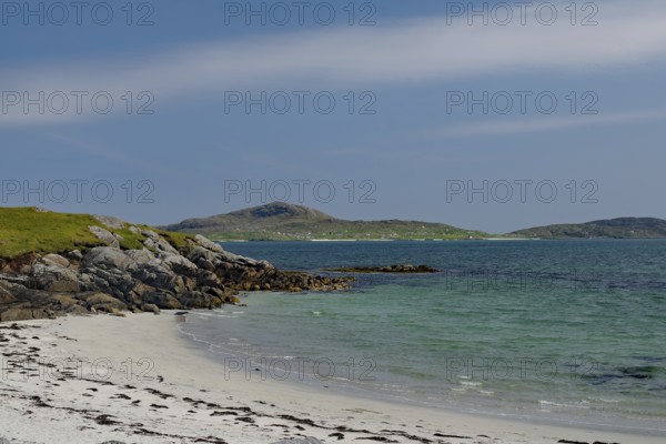 Quiet beach with white sand and rocks, surrounded by blue sea and clear sky, Eriksay, South Uist, Hebrides, Scotland, United Kingdom