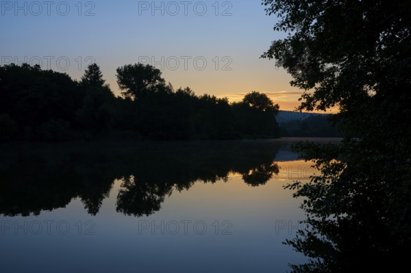 Morning sky over a quiet river Main with trees silhouetted against the orange light, summer, Grünenwört, Wertheim, Main, Main-Tauber-Kreis, Baden-Württemberg, Germany