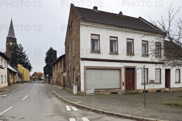 Ghost town, old village street... Kerpen Manheim in December 2018, dead town after resettlement for the Hambach open-cast lignite mine shortly in front of its demolition, birthplace and residence of Michael Schumacher, view of the abandoned church of St Albertus and abandoned houses in preparation for the expansion of RWE's lignite mining, Hambach, Lower Rhine, Rhine-Erft district, North Rhine-Westphalia, Germany, Western Europe