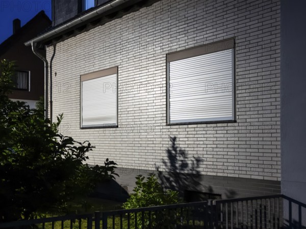 A detached house illuminated by a street lamp with the shutters down, night shot, Hilden, Germany