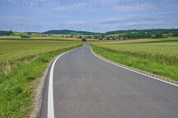 A winding country road leads through a rural landscape with hills and meadows and small villages, Orferode, town of Bad Sooden-Allendorf, Werra-Meißner-Kreis, Hesse, Germany