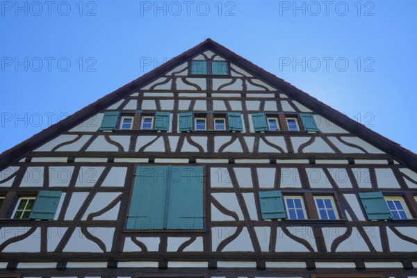 Gable facade of a half-timbered house with green shutters against a blue sky, Triberg im Schwarzwald, Schwarzwald-Baar-Kreis, Black Forest, Baden-Württemberg, Germany