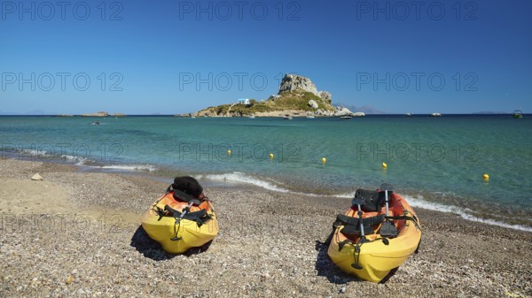 Two kayaks on the beach with a view of a small island in the blue sea, Agios Stefanos Beach, Agios Stefanos Basilica, Chapel of Agios Nikolaos, Kastri Island, Kos, Dodecanese, Greek Islands, Greece