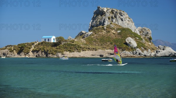 Island with windsurfer and chapel, surrounded by turquoise water, Agios Stefanos Beach, Agios Stefanos Basilica, Chapel of Agios Nikolaos, Kastri Island, Kos, Dodecanese, Greek Islands, Greece