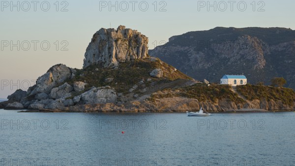 A small island with a chapel on a rock, surrounded by calm sea at sunrise, Agios Stefanos Beach, Agios Stefanos Basilica, Chapel of Agios Nikolaos, Kastri Island, Kos, Dodecanese, Greek Islands, Greece