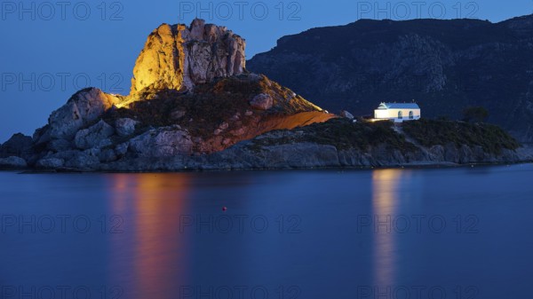 An idyllic night view of an illuminated island with a chapel and calm sea, Agios Stefanos Beach, Agios Stefanos Basilica, Agios Nikolaos Chapel, Kastri Island, Kos, Dodecanese, Greek Islands, Greece