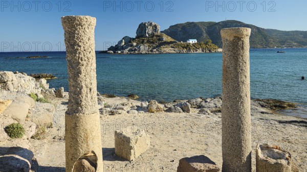 Ancient columns on the coast with a view of an island and the blue sea, Agios Stefanos Beach, Agios Stefanos Basilica, Agios Nikolaos Chapel, Kastri Island, Kos, Dodecanese, Greek Islands, Greece