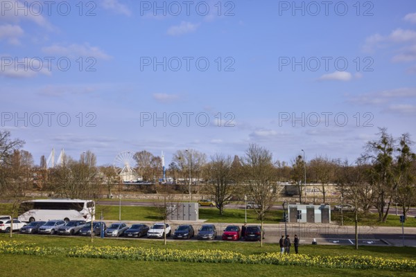 Gardens, lawn, flower bed, bare wintry trees, parking boxes, cars, coach, funfair, Ferris wheel, blue sky, cumulus clouds, Fürstenwallstraße, Schleinufer, Magdeburg, state capital, independent city, Saxony-Anhalt, Germany