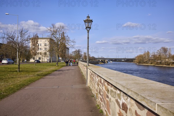 River Elbe, riverside promenade, sandstone wall, lantern, lawn, bare winter trees, car and pedestrian bridge, blue sky, cumulus clouds, Neue Strombrücke, Schleinufer, Magdeburg, state capital, independent city, Saxony-Anhalt, Germany