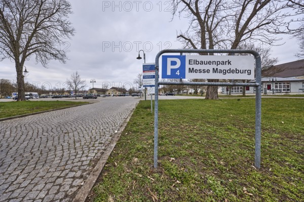 Car park, Elbauenpark, Magdeburg Trade Fair, cobblestone street, bare winter trees, lawn, lantern, diffuse light, cloudy, Tessenowstraße, Magdeburg, state capital, independent city, Saxony-Anhalt, Germany