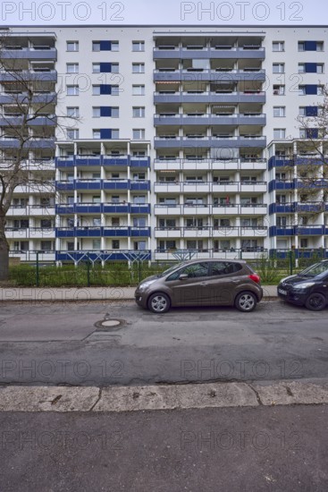 High-rise buildings, residential buildings, residential silos, facade, window, balcony, car park with vehicles, bare winter trees, diffuse light, cloudy, Victor-Jara-Straße, Magdeburg, state capital, independent city, Saxony-Anhalt, Germany