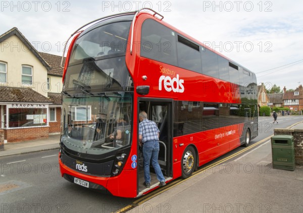 Passengers boarding Salisbury Reds double decker bus service X5 at Pewsey, Wiltshire, England, UK
