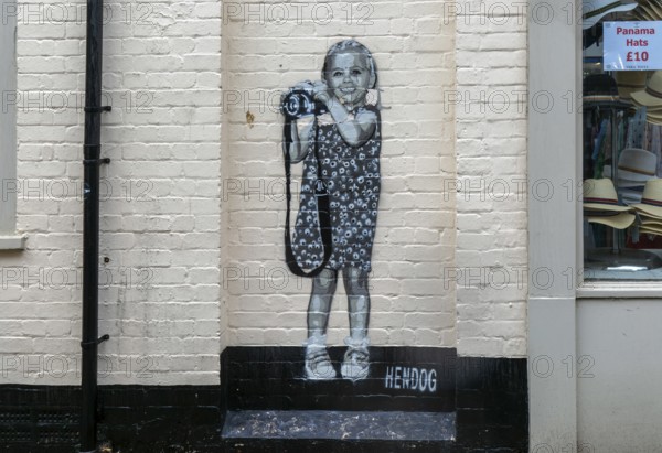Smile artwork mural by Hendog of smiling girl child holding camera created 2021, Butcher Row, Salisbury, Wiltshire, England, UK