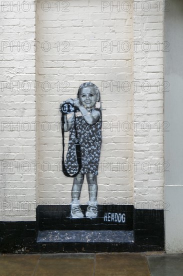 Smile artwork mural by Hendog of smiling girl child holding camera created 2021, Butcher Row, Salisbury, Wiltshire, England, UK