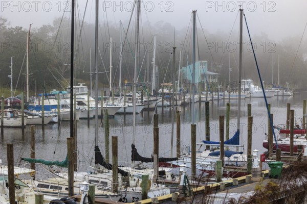 Private sailboats and fishing boats in the harbor at Ocean Springs, Mississippi on a foggy morning