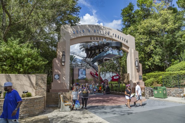 Masked park guests exiting under the entrance sign for the Rock 'n' Roller Coaster ride at Disney's Hollywood Studios theme park