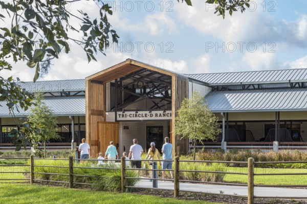 Family entering the Tri-Circle-D Ranch horse stables in the Fort Wilderness Campground and Resort at Disney World in Orlando, Florida