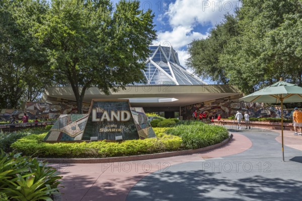 Family and senior couple entering The Land attraction in Epcot at Walt Disney World in Orlando, Florida