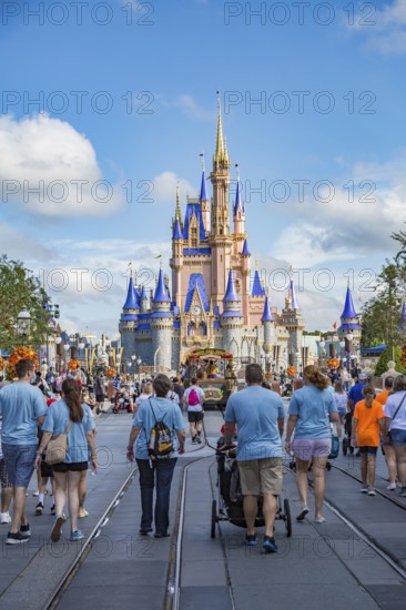 Family walks toward Cinderella's Castle at the end of Main Street in the Magic Kingdom at Walt Disney World, Orlando, Florida