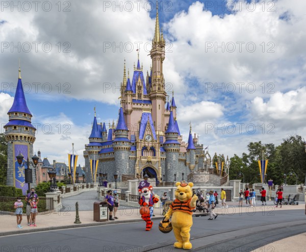 Winnie the Pooh and Tigger walk past Cinderella's Castle at the end of Main Street in the Magic Kingdom at Walt Disney World, Orlando, Florida