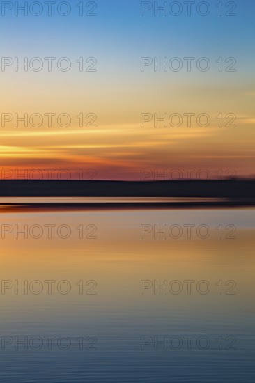 Motion blurred abstract lake at sunset background or wallpaper