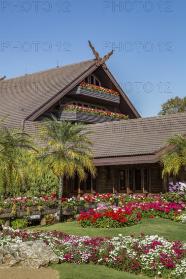 Ornate trees and lush flower gardens enhance the Lanna and Swiss architecture of the Doi Tung Royal Villa inside the Doi Tung tourist attraction in Chiang Rai, Thailand