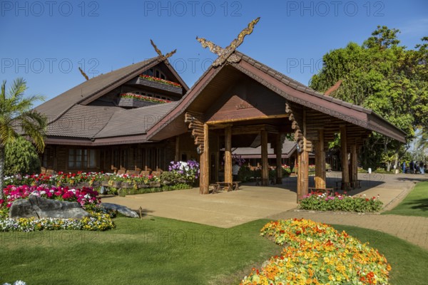 Ornate trees and lush flower gardens enhance the Lanna and Swiss architecture of the Doi Tung Royal Villa inside the Doi Tung tourist attraction in Chiang Rai, Thailand