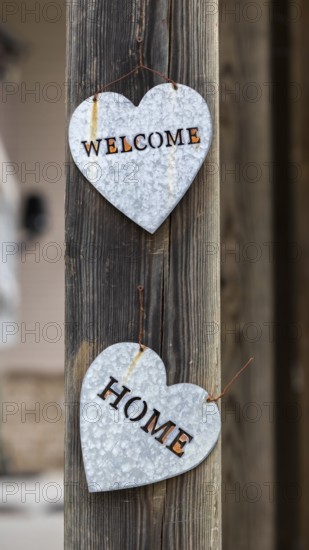 Welcome Home message in galvanized metal hearts on a wood post