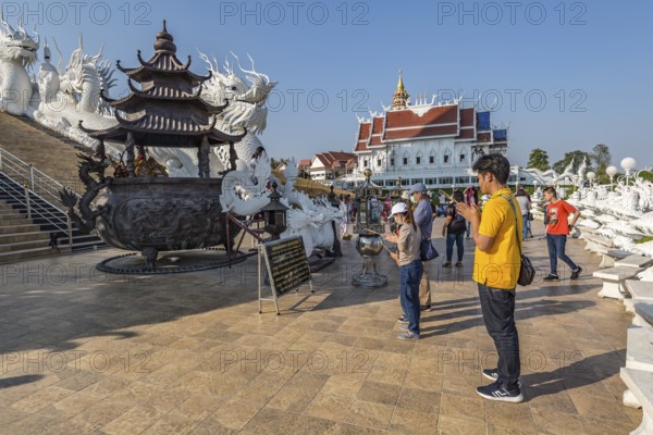 Visitors make a wai phra offering to Buddah in front of the Guan Yin (Goddess of Mercy) statue at Wat Huay Pla Kang Temple in Chiang Rai province of Northern Thailand