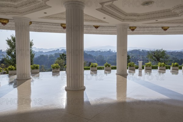Hills beyond the supporting columns under the Guan Yin (Goddess of Mercy) statue at Wat Huay Pla Kang Temple in Chiang Rai province of Northern Thailand