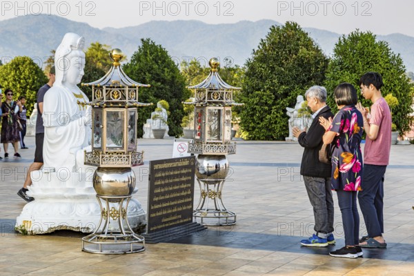 Visitors praying at the Guan Yin (Goddess of Mercy) statue at Wat Huay Pla Kang Temple in Chiang Rai province of Northern Thailand