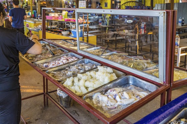 Selection of raw seafood available for customers at a buffet style outdoor restaurant in Chiang Rai province of Northern Thailand