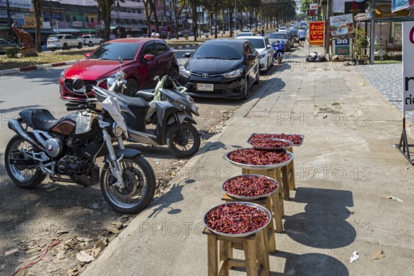 Trays of peppers on the sidewalk for sale along Ban Du street in Chiang Rai, Thailand