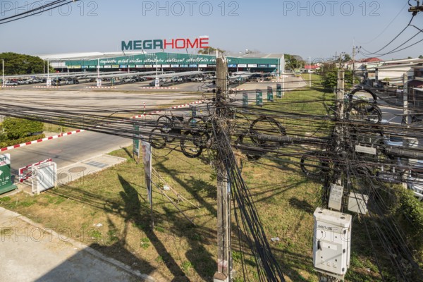 Tangled mess of utility wires in front of the Mega Home Center building materials store in Chiang Rai, Thailand