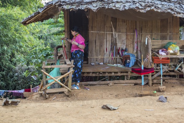 Woman weaving items to sell at the Union of Hill Tribe Villages outside of Chiang Rai in the Nanglae District of Thailand
