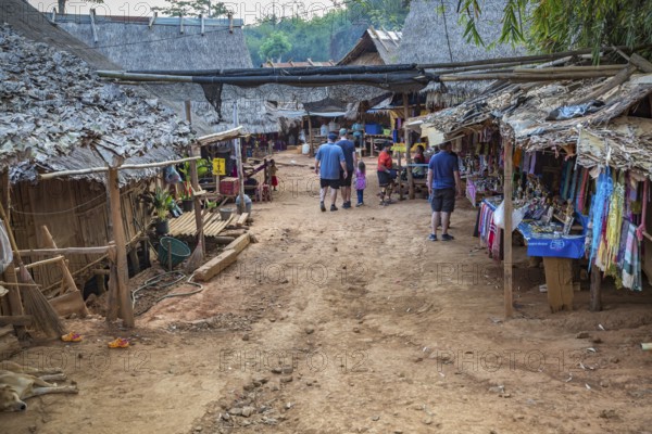 American tourists walking through the Long Neck Karen tribe (more properly called the Kayah Lahwi tribe) area of the Union of Hill Tribe Villages outside of Chiang Rai in the Nanglae District of Thailand