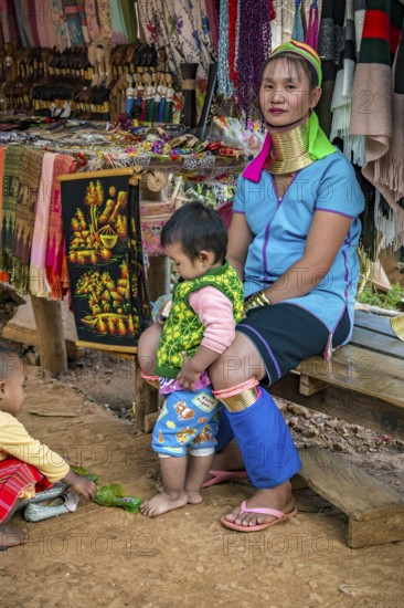 Tribal woman with two children in the Long Neck Karen tribe (more properly called the Kayah Lahwi tribe) area of the Union of Hill Tribe Villages outside of Chiang Rai in the Nanglae District of Thailand