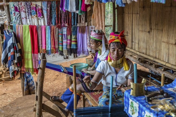 Tribal women weaving scarves to be sold in the Long Neck Karen tribe (more properly called the Kayah Lahwi tribe) area of the Union of Hill Tribe Villages outside of Chiang Rai in the Nanglae District of Thailand