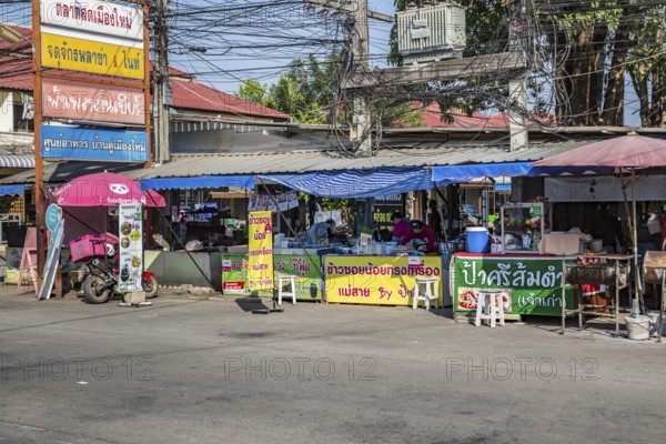 Thai woman preparing food at her streetside business in Chiang Rai province of Northern Thailand