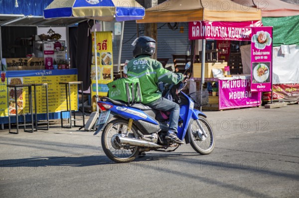 Food delivery driver picking up an order for a delivery in Chiang Rai, Thailand